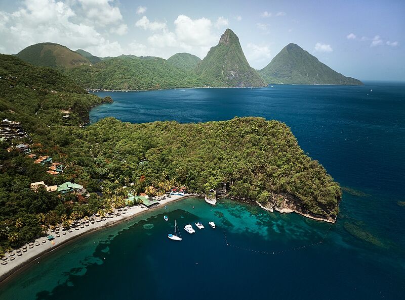 Nicht zu übersehen: Die Pitons sind das Wahrzeichen von St. Lucia Panoramablick auf die Pitons in St. Lucia, Karibik – tropische Bucht mit Strand, Segelbooten und türkisblauem Meer