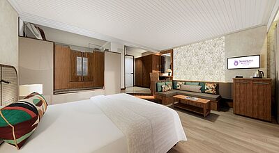 Modernes Hotelzimmer im Shandrani Beachcomber Resort & Spa auf Mauritius mit Doppelbett, Sitzecke, TV und stilvollem Interieur