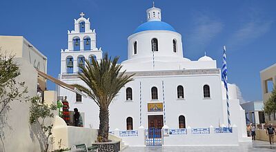 Eine griechische Kirche mit einer blauen griechischen Kuppel 