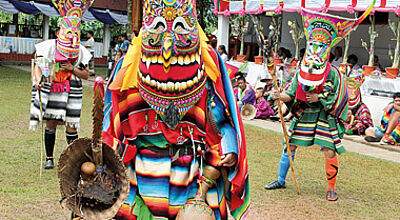 Offenes Maul und lange Nase: drei Maskierte im Ponchai-Tempel
