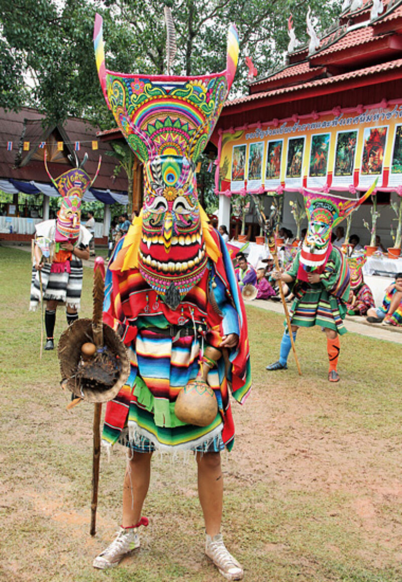 Offenes Maul und lange Nase: drei Maskierte im Ponchai-Tempel