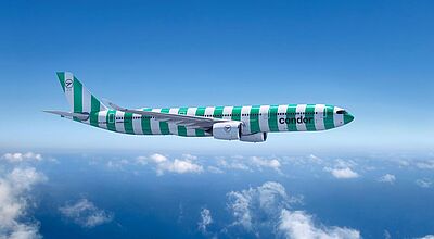   Ein Airbus A330-900neo der Fluggesellschaft Condor in grüner und weißer Streifenlackierung („Island“-Design) fliegt über den Wolken bei blauem Himmel.