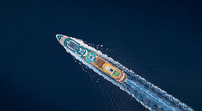 Die Aida-Kreuzfahrten für übernächsten Sommer sind ab sofort im Verkauf. Foto: Skynamic Luftaufnahme eines Kreuzfahrtschiffs auf hoher, dunkler See und in voller Fahrt.