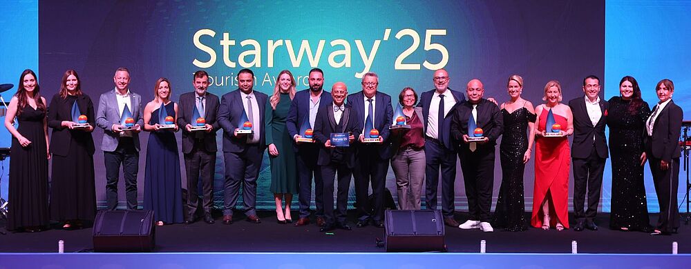 Bild von einer Bühne mit vielen Menschen, die mit Preisen für ihre guten Vertriebsleistungen im Reisevertrieb ausgezeichnet wurden.