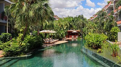 Luxuriöser Hotelpool im TUI Blue Angkor Grace in Kambodscha, umgeben von tropischen Palmen, Sonnenliegen und moderner Architektur – perfekte Oase für Erholung und Wellnessurlaub.