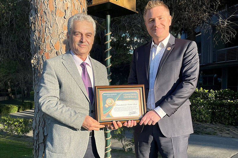 Bentour-Geschäftsführer Deniz Ugur (rechts) nimmt die Urkunde von Fuat Nur, Vizedirektor des türkischen Forstministeriums, entgegen