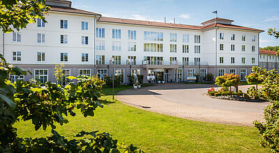 Großes Hotelgebäude mit Wiese im Vordergrund