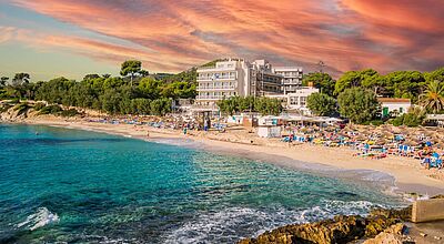 Ein Hotel steht am feinsandigen Strand auf Mallorca mit einer tollen Himmelsfärbung