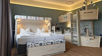Ein Hotelsimmer im TUI Kids Club an der Nordsee mit Doppelbett und Stockbett in Schiffform