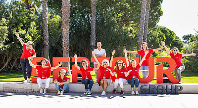 Jubelnde Menschen vor Palmen in einem Park