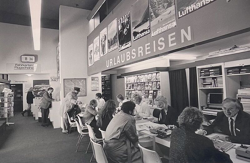 Historisches Reisebüro in Deutschland mit Beratung zu Urlaubsreisen und Flugtickets – Lufthansa-Werbung im Hintergrund – Einblick in die Entwicklung des Tourismus und Reisevertriebs wohl in den 1970er-Jahren