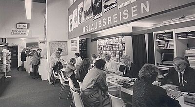 Historisches Reisebüro in Deutschland mit Beratung zu Urlaubsreisen und Flugtickets – Lufthansa-Werbung im Hintergrund – Einblick in die Entwicklung des Tourismus und Reisevertriebs wohl in den 1970er-Jahren