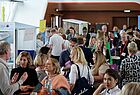 Blick in eine Halle mit vielen Menschen, die in Gespräche vertieft sind