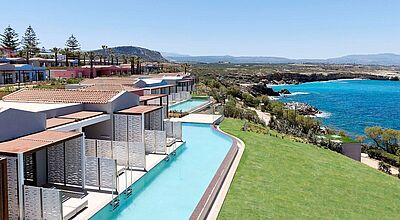 Ein Hotelgebäude auf einer Klippe über dem Meer. Jedes der Zimmer hat einen Pool
