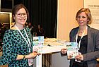 Petra Krüger (links) und Julia Bös von Thomas Cook präsentieren die neuen Reiseunterlagen. Die kosten künftig in gedruckter Form drei Euro. 