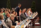 Viele Menschen in einem dunklen Konferenzraum sitzend