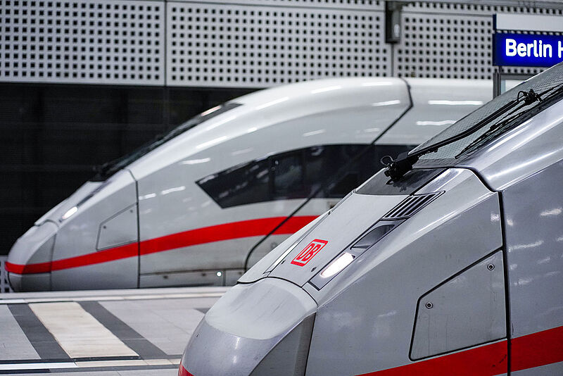 Auf Gleisen im Berliner Hauptbahnhof stehen zwei Zugwagen der Deutschen Bahn, darunter ein weißer ICE der jüngsten Flottengeneration