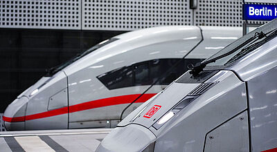 Auf Gleisen im Berliner Hauptbahnhof stehen zwei Zugwagen der Deutschen Bahn, darunter ein weißer ICE der jüngsten Flottengeneration