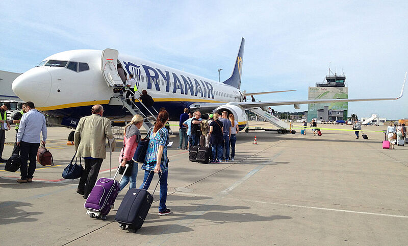 Ryanair erlaubt jetzt größeres Handgepäck, will aber auch strenger kontrollieren Passagiere mit Rollkoffern gehen auf dem Vorfeld des Flughafens Frankfurt-Hahn zu einer Maschine von Ryanair, um dort einzusteigen.