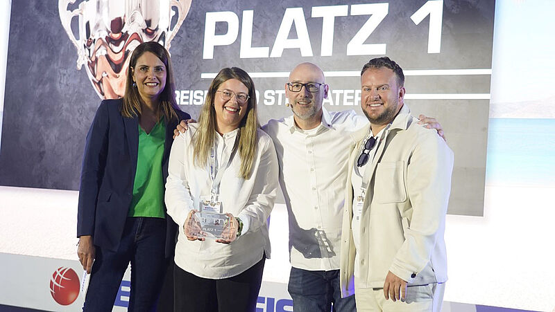 Preisverleihung Touristik: Best-Reisen Team erhält Auszeichnung Platz 1 – Gruppenfoto mit Trophäe bei Branchenevent, links stehen zwei Frauen, rechts zwei Männer