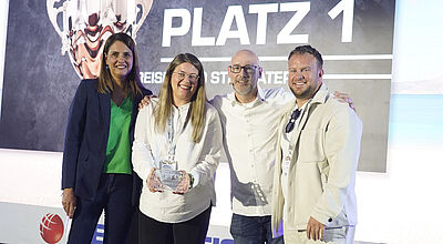 Preisverleihung Touristik: Best-Reisen Team erhält Auszeichnung Platz 1 – Gruppenfoto mit Trophäe bei Branchenevent, links stehen zwei Frauen, rechts zwei Männer