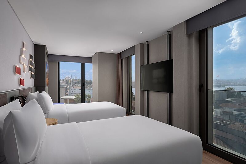 Modernes Hotelzimmer im Aloft Hotel Istanbul mit zwei komfortablen Betten, großer Fensterfront, Stadtblick auf Istanbul und Blick auf den Bosporus