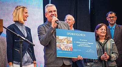 Geschäftsführer Christoph Führer übergab bei der Jubiläumsfeier eine Spende zum Bau einer dritten Leitner-Schule, die in Uganda entsteht