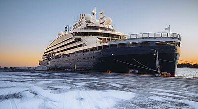 Die Le Commandant Charcot kreuzt im Winter 2026/2027 auch ab und bis Helsinki. Foto: Ponant/Julien Fabro An der leicht verschneiten Pier in Helsinki liegt ein moderner Eisbrecher mit dunkelblauem Rumpf und weißem Aufbau