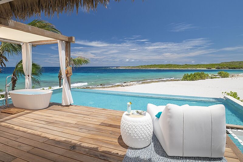 Luxuriöse Strandvilla mit Infinity-Pool, Outdoor-Badewanne und Meerblick – exklusiver Urlaub auf einer tropischen Insel mit weißem Sandstrand, türkisblauem Wasser und stylischem Lounge-Bereich für pure Entspannung.