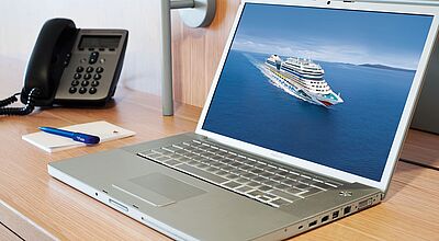 Aida-Berater müssen nicht mehr nur mit online-Material beraten Ein Laptop, auf dem ein Aida-Schiff zu sehen ist. Naben ein Telefon