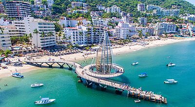Luftaufnahme von Puerto Vallarta mit dem modernen Pier 'Malecón de los Muertos', Booten im türkisblauen Meer und Hotels entlang der Küste in Jalisco, Mexiko