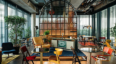 Viele unterschiedliche, bunte Stühle vor einer Bar