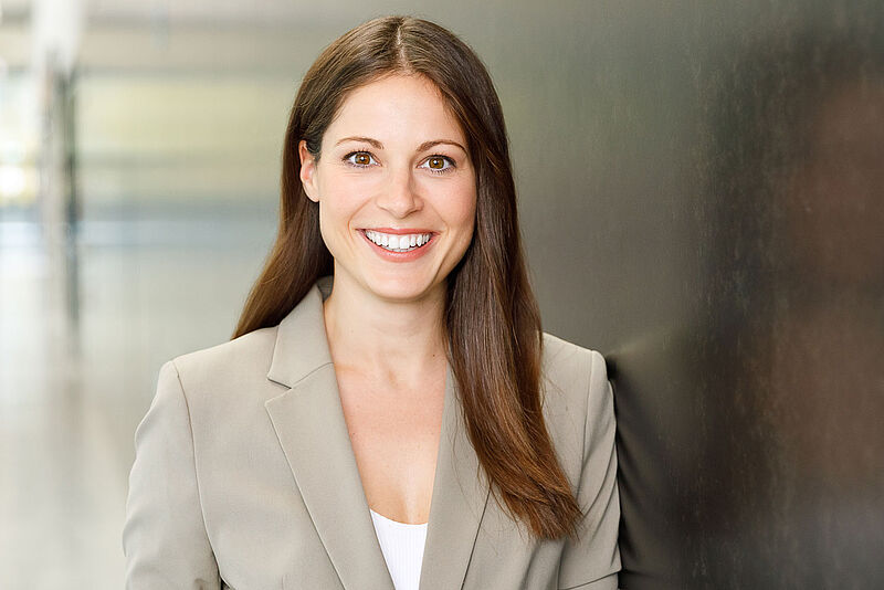 Porträtfoto einer freundlichen, lachenden jungen Frau im Business Outfit
