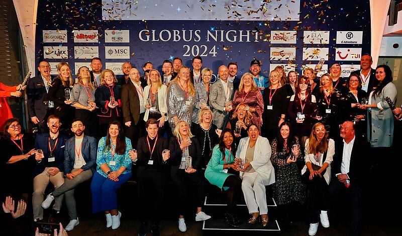 Viele Menschen mit Pokalen auf einer Bühne vor Schriftzug Globus Night 2024