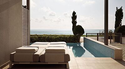 Luxuriöse private Terrasse mit Pool und Meerblick im Mare Resort in Paphos, Zypern – moderne Sonnenliegen, elegantes Design und mediterrane Landschaft für einen exklusiven Urlaub.