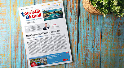 Titelseite der Fachzeitung „touristik aktuell“ (Ausgabe Nr. 10, 20. Mai 2025) auf einem blauen Holztisch mit Pflanzenkorb. Haupttitel: „Der Counter ist effizienter geworden“, dazu ein Artikel über Umsatzrenditen im Reisebüro-Vertrieb. Oben Werbung für Schmetterling Reisen (DOM-REP – Punta Cana), unten Werbung für alltours (Hotel auf Rhodos).