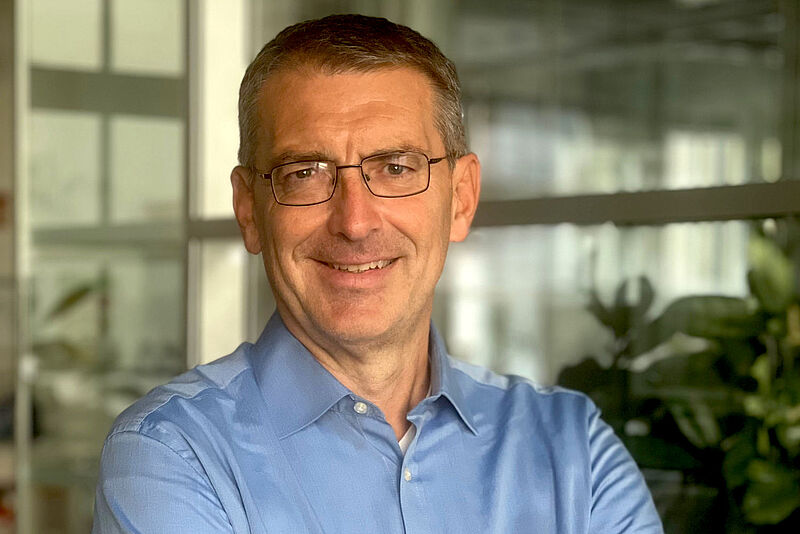 Neues Gesicht beim Flugeinkauf von Aerticket: der ehemalige FTI-Manager Markus Denz. Foto: privat Legeres Porträt eines Managers im mittleren Alter in einem blauen Hemd vor unscharfem Hintergrund eines Büroraumes mit Grünpflanzen.