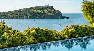 im Vordergrund ein Pool, das blaue Meer und im Hintergrund der Poseidontempel auf einer Landzunge 