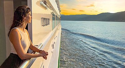 Croisi Europe wird ab 2027 auf dem Amazonas aktiv Eine Frau steht an einer Schiffsreling und schaut auf das Wasser. Man kann das Ufer erkennen