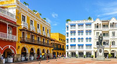 Ein kolonialer Platz in der Altstadt von Cartagena mit einer Statue. Drum herum sind Häuser, teils in bunten Farben 