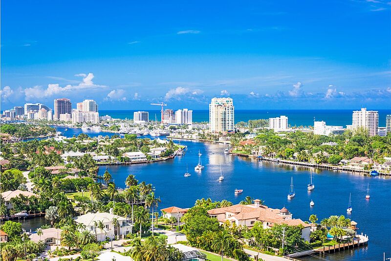 Blick auf Fort Lauderdale in Florida, USA Foto: Sean Pavone/iStock Luftbild von einer Stadt unter blauem Himmel, die von Flüssen durchzogen ist und am Meer liegt.