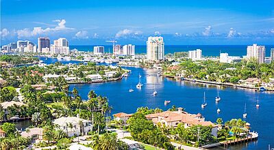 Blick auf Fort Lauderdale in Florida, USA Foto: Sean Pavone/iStock Luftbild von einer Stadt unter blauem Himmel, die von Flüssen durchzogen ist und am Meer liegt.