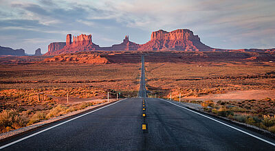 Vor allem für Nordamerika-Reisen hat Eberhardt Travel die Preise gesenkt. Foto: Jaroslav Sugarek/iStock Die ikonische lange und gerade Straße durch das Monument Valley führt durch eine Wüstenlandschaft zu den berühmten rötlichen Sandsteinfelsen, die im Sonnenuntergang leuchten.