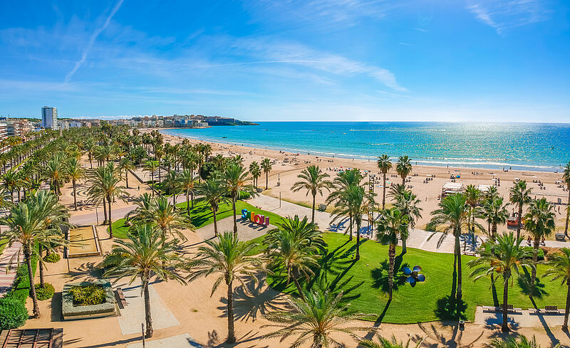 Sonniger Strand von Salou an der Costa Dorada in Spanien mit Palmenpromenade, feinem Sandstrand und Blick auf das Mittelmeer