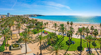 Sonniger Strand von Salou an der Costa Dorada in Spanien mit Palmenpromenade, feinem Sandstrand und Blick auf das Mittelmeer