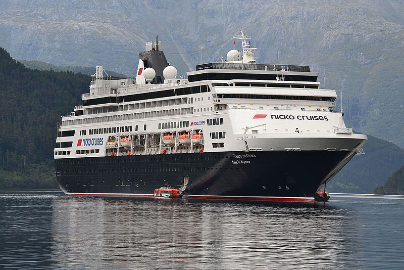 Die auf rund 1.000 Passagiere beschränkte Vasco da Gama im Hardangerfjord in Norwegen. Das Kreuzfahrtschiff Vasco da Gama mit schwarzem Rumpf ankert in einem norwegischen Fjord, umgeben von steilen Bergwänden und ruhigem Gewässer.