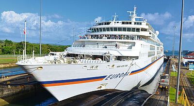 Kreuzfahrtschiff MS Europa von Hapag-Lloyd in einer Schleuse des Panamakanals, umgeben von tropischer Vegetation.