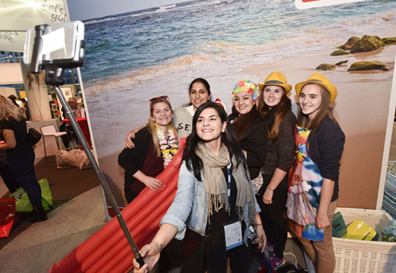 Reiseverkäufer testen das Fotografieren mit dem Selfie Stick auf der Travelconnexion 2014