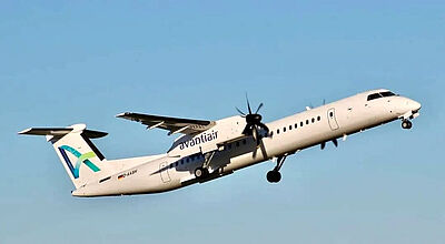 Ein weißes Flugzeug der Airline Avanti Air vom Typs Dash-8-400 mit Firmenlogo im Steigflug vor blauem Himmel bei Sonnenschein.