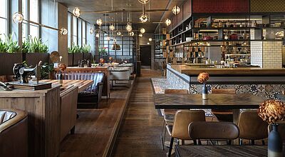 Modernes Hotelrestaurant in Berlin mit stilvollem Interieur, offener Showküche, gemütlichen Sitzbereichen und  eleganter Beleuchtung – ideales Ambiente für kulinarische Erlebnisse und Genussreisen
